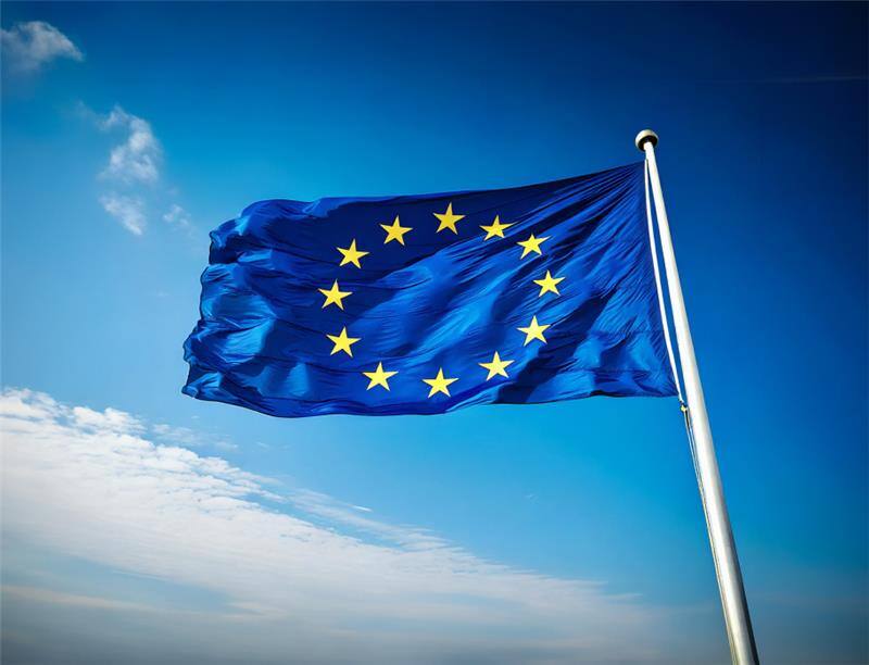 Europese vlag met blauwe lucht en wolken op de achtergrond